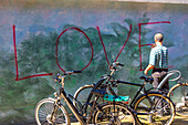 Wand mit Graffiti. Ein Mann wischt die Farbe weg