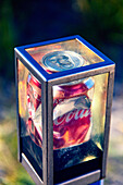 Can of Coke in a transparent crate