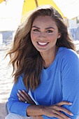 Woman in blue jumper sitting on the beach