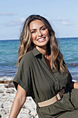 Woman in khaki coloured dress on the beach