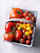 Different types of tomatoes in a wooden basket