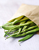 Green broad beans in a paper bag