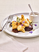 Deep-fried cauliflower and herbs on beetroot