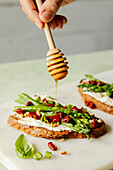 Toasted bread with asparagus, sun-dried tomatoes and honey