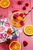 Water with raspberry and orange ice cubes