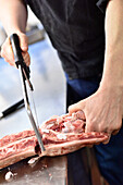 Cutting the lamb with a saw, removing the leg