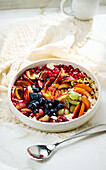 Fruit porridge bowl with oat flakes and nuts