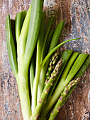 Spring onions and green asparagus on a rustic base