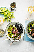 Wild asparagus salad with steak strips, black pasta and chimichurri