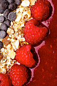 Açaí bowl with raspberries, nuts and chocolate drops