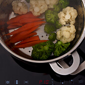 Carrots, cauliflower, broccoli in a steamer insert