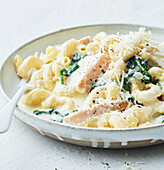 Creamy macaroni with chicken, cheese and spinach leaves