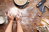 Knead bread dough with flour and accessories on a wooden worktop