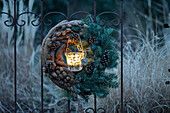 Winter wreath made from fir and pine branches with a glowing lantern