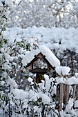 Vogelhaus im verschneiten Garten im Winter