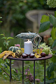 Windlicht mit Herz aus Heide auf herbstlich dekoriertem Tisch im Garten