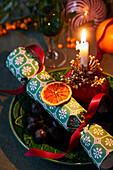 Weihnachtlich gedeckter Tisch mit Knallbonbon und Kerze