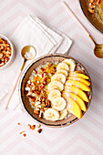 Mango, coconut and chia pudding with banana slices and nuts