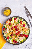 Iceberg lettuce with salmon, cucumber, raspberries and lemon pepper