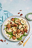 Grilled courgette with meatballs and lemon yoghurt on rocket