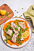 Cod, green beans and peas on a pumpkin puree