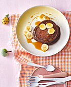 Chocolate pancakes with banana slices and maple syrup