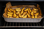 Potato wedges with herbs and spices in the oven