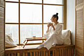 Woman sitting at the window with a teacup