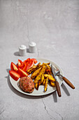 Baked beef meatball with potato wedges and vegetables