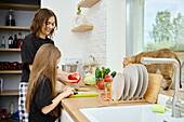 Mother and child cleaning peppers