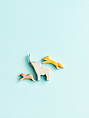Three wooden animal figures on a pastel-coloured background