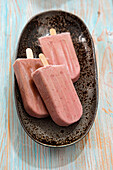 Strawberry and banana ice cream on a stick