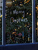 Weihnachtlich dekoriertes Fenster mit Schriftzug "Merry Christmas"