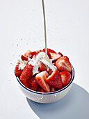 Pour cream over strawberries