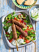 Grilled beef kebabs with tzatziki and salad