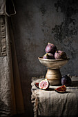 Whole and sliced figs in a rustic bowl