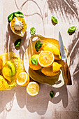 Whole and sliced lemons with basil leaves