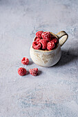 Frozen raspberries in a ceramic cup