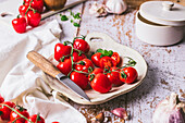 Cherry tomatoes with herbs and knife on plate