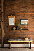 Rustic wooden wall with bench, mirror and decorative elements