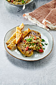 Pork neck steaks with eggplant dip and bread sticks