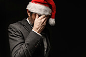 Sad businessman with Santa hat