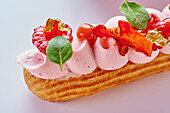 Éclair with raspberry cream and gold leaf