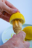 Man's Hands Squeezing Lemon with Juicer