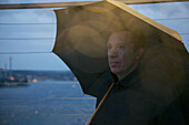 Portrait of Man on Observation Deck under Umbrella