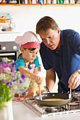 Father and Daughter Cooking in Kitchen