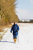 Frau beim Wandern auf schneebedecktem Feld