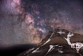 The Milky Way rising over the peak of Mt. Blakiston, in Waterton Lakes National Park, Alberta, Canada. This was June 10/11, 2024, so some snow still remains at high altitudes. This is an example of a "deepscape" — a nightscape taken with a longer focal length lens than is usual for nightscapes, to frame a fragment of a landscape below an interesting area of sky with notable deep-sky objects.