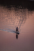 Standup paddleboarding at sunset in Ebro River, Zaragoza, Spain