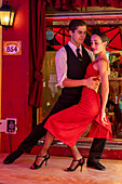 An attractive young couple dances the tango on El Caminito in the La Boca barrio of Buenos Aires, Argentina.